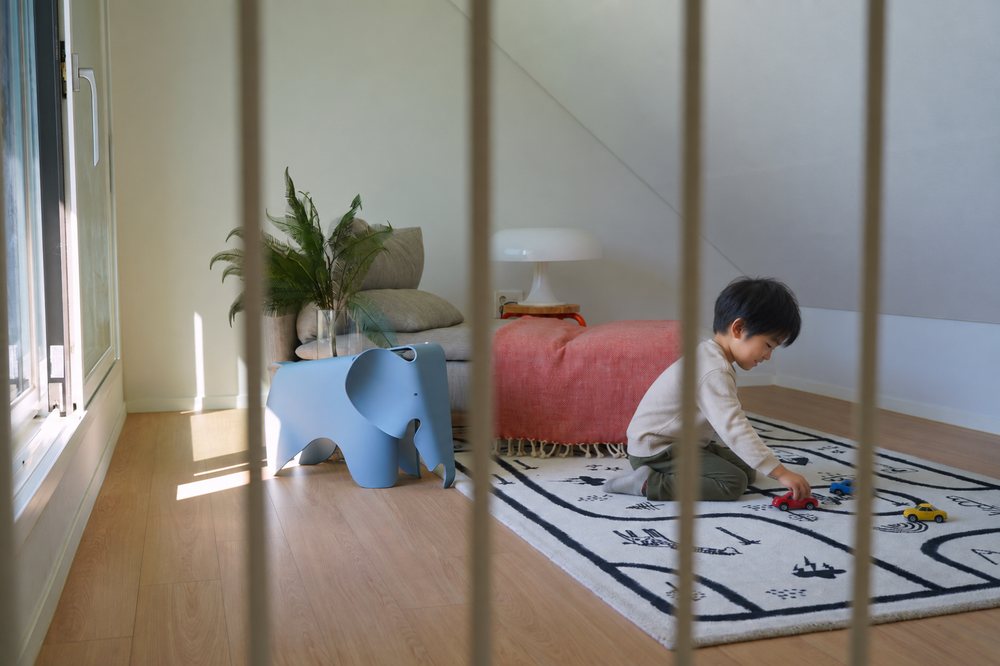 다락 러그에서 장난감 자동차를 가지고 노는 아이를 연출한 장면